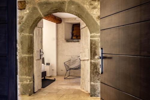 une arche menant à un couloir avec une porte dans l'établissement Pierres plates, à Annecy