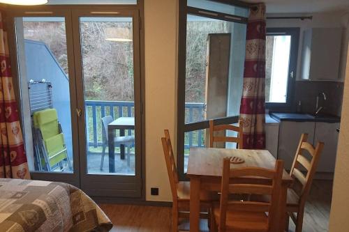 une cuisine et une salle à manger avec une table et des chaises dans l'établissement Studio au Cœur de la Tarentaise, à La Lechere