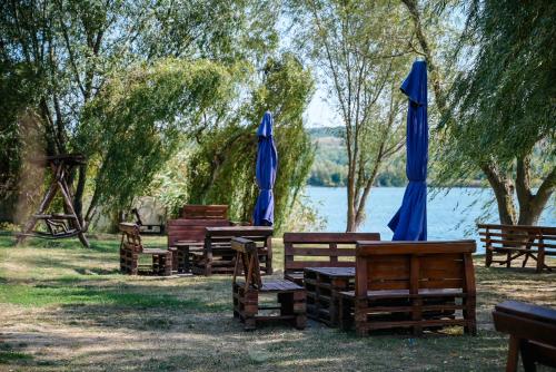 a group of wooden benches with blue umbrellas at Садиба на Кодимі in Archipitovka