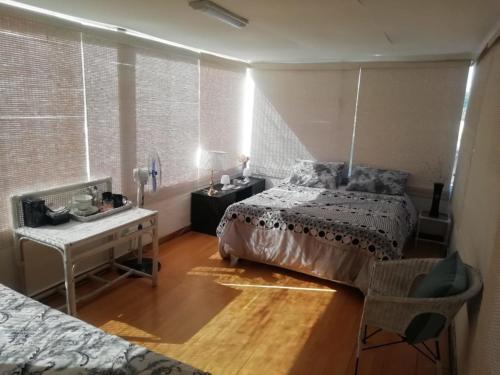 Un dormitorio con una cama, una mesa y un escritorio. en 11 on Orange, en Ciudad del Cabo