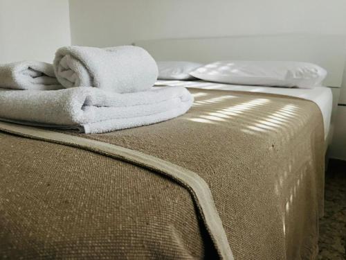 a bed with towels sitting on top of it at SHUBY HOME in San Pietro Vernotico