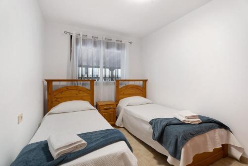 two twin beds in a room with a window at Bonito Apto Mirador de la Gomera By Paramount Holidays in Callao Salvaje