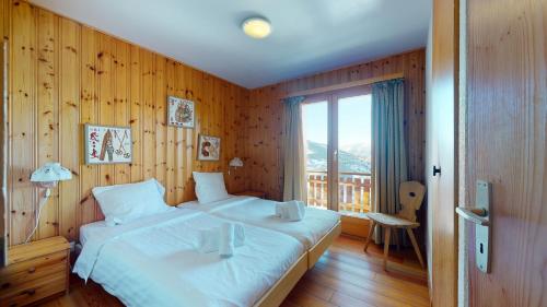 a bedroom with a large white bed with a balcony at Tschoueilles 5 MOUNTAIN & QUIET chalet 10 pers in Veysonnaz