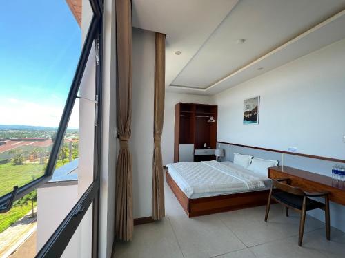 a bedroom with a bed and a desk and a window at Khách sạn Phương Trinh in Pleiku