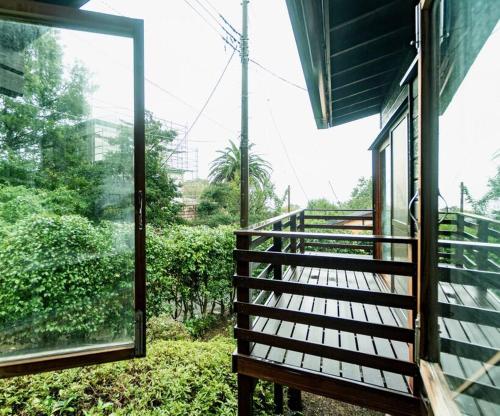 a balcony of a house with a window at VOYAN villa 伊豆 in Futo