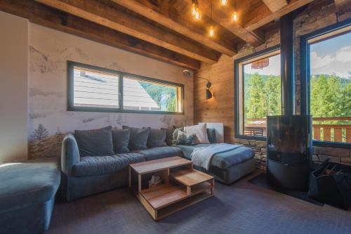 a living room with a couch and a table at Le Refuge des Castorres - Chalet moderne in Les Orres