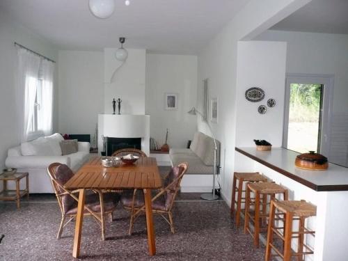 a kitchen and living room with a table and chairs at Pine Tree Cottage in Nea Skioni