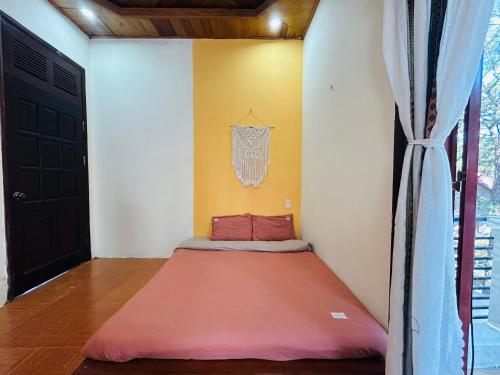 a small bed in a room with a window at Chino Homestay Măng Đen - Villa tại Măng Đen in Kon Tum