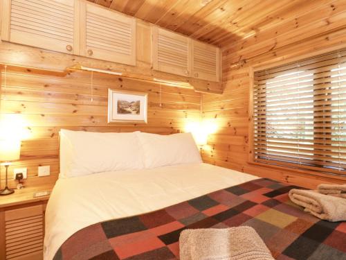 a bedroom with a bed in a log cabin at Ennerdale Lodge in Keswick