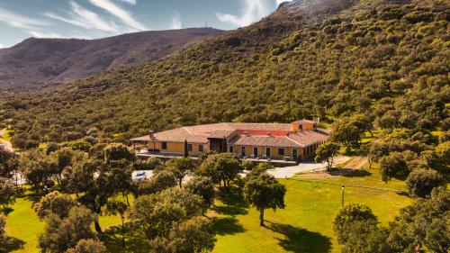 una vista aerea di una casa in una montagna di Hotel Resort Hípico El Hinojal a Montánchez