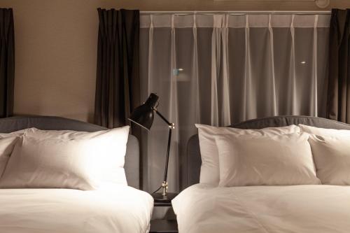 a mannequin standing between two beds in a hotel room at Maison Roppongi in Tokyo