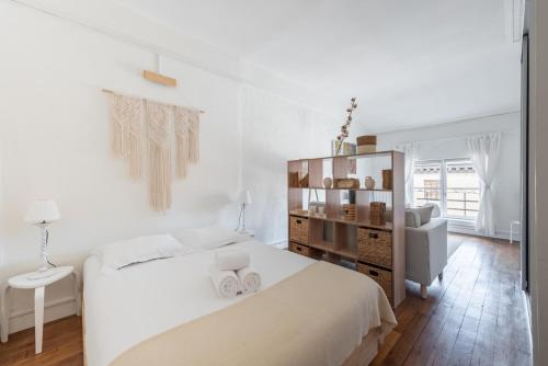 une chambre blanche avec un lit blanc et une chaise dans l'établissement Angelina - Proche de la Place Bellecour, à Lyon