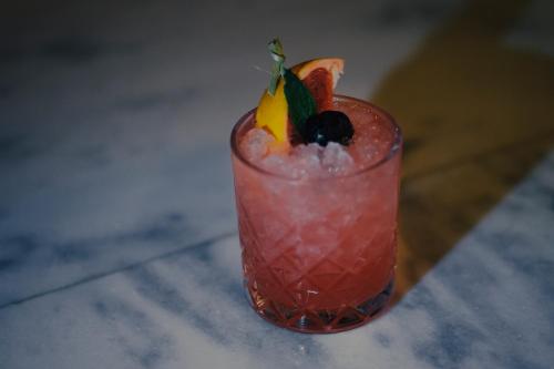 a cocktail with fruit and ice on a table at Kenta Beach Hotel in Agios Ioannis Pelio