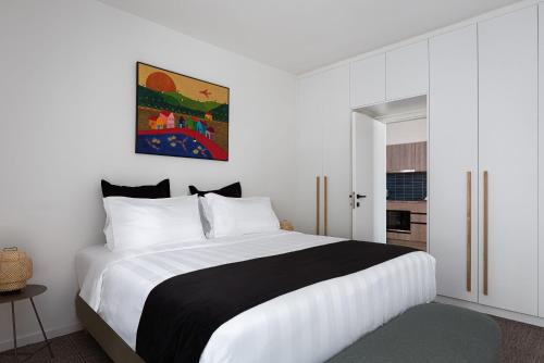 a bedroom with a large bed with white and black sheets at Glyfada Unique Residence in Athens