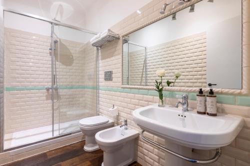 uma casa de banho com um lavatório, um WC e um chuveiro em Alla Corte Guest House em Roma