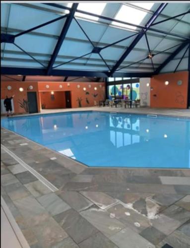 a large blue swimming pool in a building at 2 Bedroom Villa - Lakeside Holiday Park in Merston