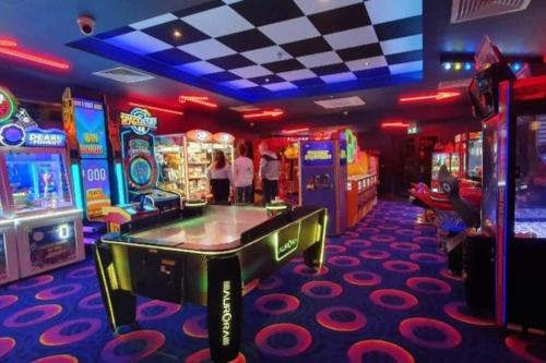 una sala de juegos con la gente jugando un videojuego en 2 Bedroom Villa - Lakeside Holiday Park en Merston