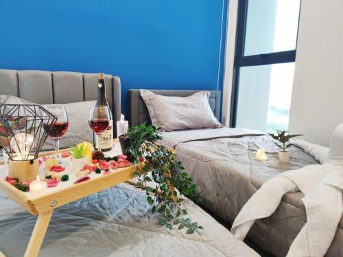 una mesa con dos copas de vino en una cama en Citizen2 Sunway Mid Valley Suites, en Kuala Lumpur