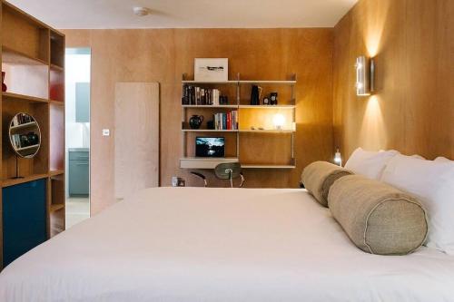 - une chambre avec un grand lit blanc et des étagères dans l'établissement Seahorse Studio, Aldeburgh, à Aldeburgh