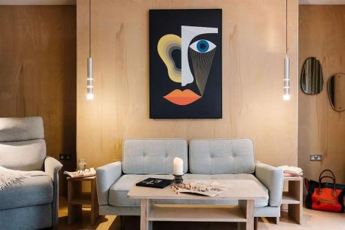 a living room with a couch and a painting on the wall at Seahorse Studio, Aldeburgh in Aldeburgh