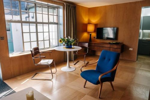 a living room with a table and chairs and a tv at Seahorse Studio, Aldeburgh in Aldeburgh