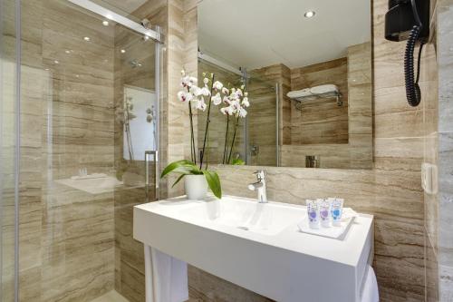 a bathroom with a white sink and a mirror at Grupotel Amapola in Playa de Muro