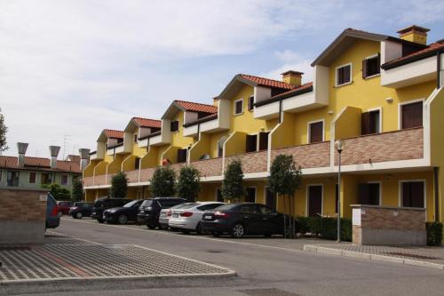 uma fila de edifícios com carros estacionados num parque de estacionamento em Enjoy your stay in our nice flat with pool em Rosapineta
