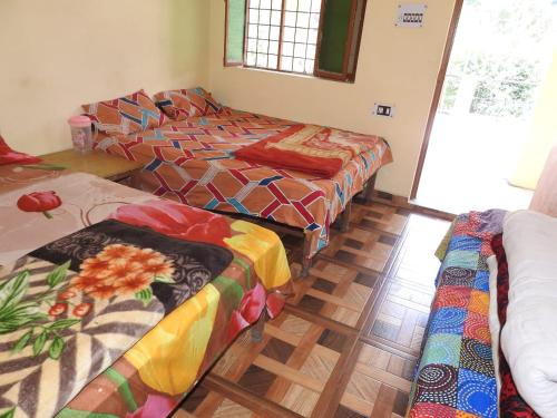a room with three beds in a room at New Shiv Palace by StayApart in Ukhimath