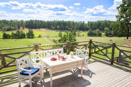 una mesa y sillas en una terraza con vistas a un campo en Ängagården - Gårdshuset, en Våxtorp