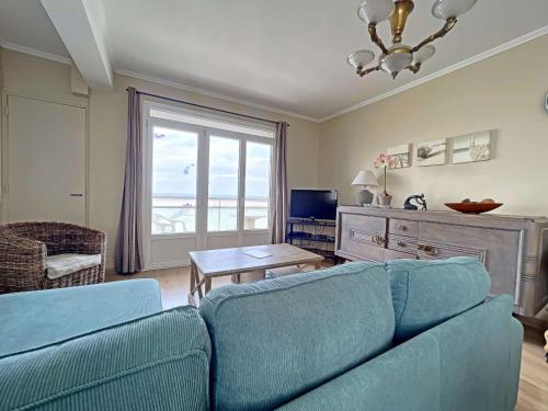 un salon avec un canapé bleu et une fenêtre dans l'établissement Magnifique T4 avec balcon et garage à Berck-Plage - FR-1-646-48, à Berck-sur-Mer