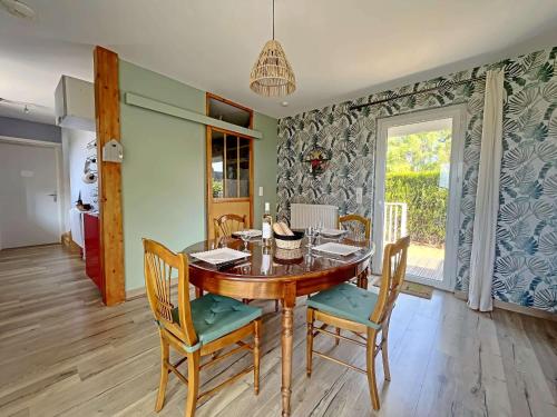 une salle à manger avec une table et des chaises en bois dans l'établissement Charmante maison avec jardin, piscine et parking - FR-1-646-54, à Groffliers