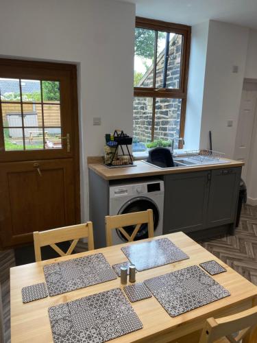 a kitchen with two tables and a sink and a stove at House In Padfield in Tintwistle