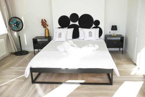 a bedroom with a large bed with black and white furniture at Srebrna Luxury Apartments - willa fabrykancka - wnętrza premium in Łódź