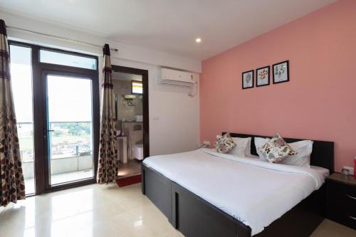 a bedroom with a large bed with pink walls at Rose 3BHK by Wabi Sabi Stays with Private Balcony in Rishīkesh