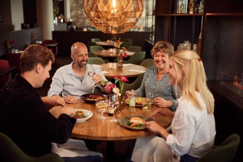 a group of people sitting around a table in a restaurant at Van der Valk Hotel Groningen-Hoogkerk in Groningen