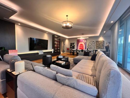 uma sala de estar com um sofá grande e uma televisão de ecrã plano em Amazing Luxury Large 4 Bedroom Apt Istinye Park 1 min 250m2 em Istambul
