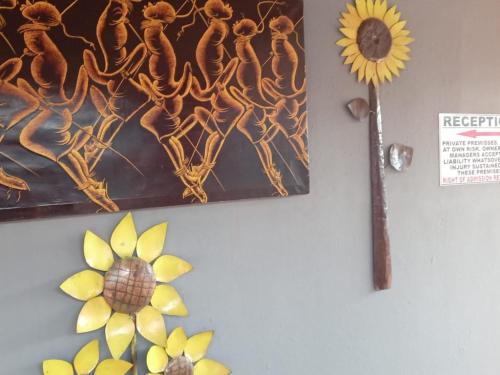 a painting on a wall with a sunflower on it at Grand Central Guesthouse in Rustenburg