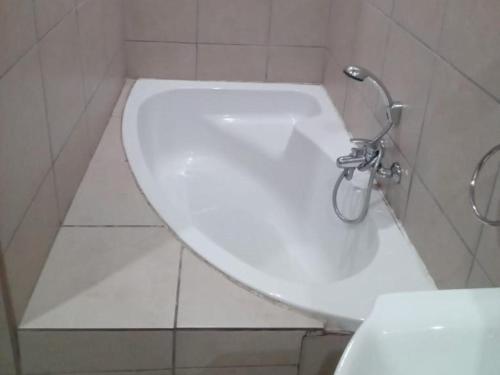 a bathroom with a white toilet and a sink at Grand Central Guesthouse in Rustenburg