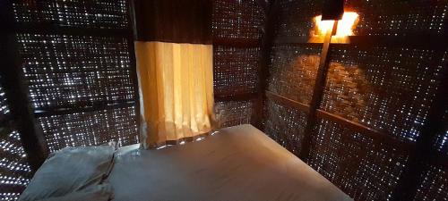 um quarto com uma cama e uma janela com uma luz em Mangosteen Garden Inn em Bonjeruk
