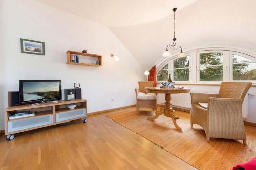 salon z telewizorem i stołem w obiekcie Natourlust Preetz - Die kleine Rote w mieście Burtevitz