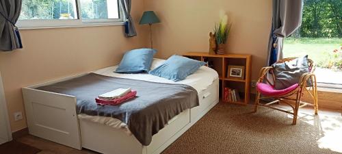 - une chambre avec un lit doté d'oreillers bleus et d'une chaise dans l'établissement Gite Puydufou -5kms- La Séraphina, 2 à 6 personnes, à Chambretaud