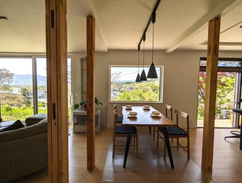 a living room with a table and chairs and a couch at Mountain View Totoro - spacious & sunny in Yoichi