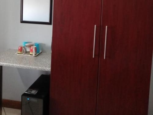 a large red cabinet in a room with a counter at Grand Central Guesthouse in Rustenburg