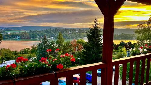 a balcony with flowers and a view of the water at Penzion Kozí Horka u Brněnské přehrady in Brno