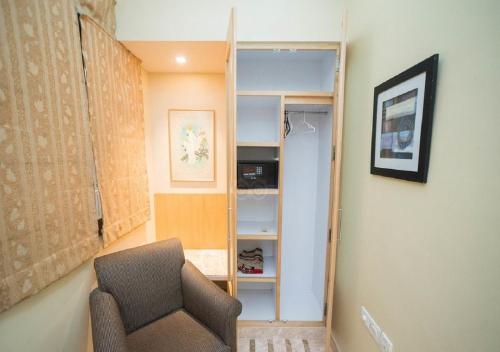 a living room with a chair and a closet at Regent Hotel in Mumbai