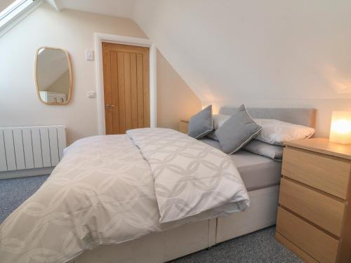 um quarto com uma cama com um espelho e uma cómoda em Spicery Barn Loft em Exeter