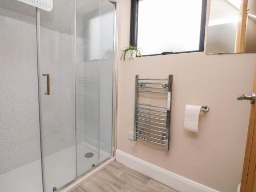 a shower with a glass door in a bathroom at Spicery Barn Loft in Exeter