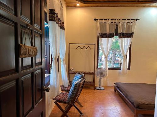 a bedroom with a bed and a chair and a window at Chino Homestay Măng Đen - Villa tại Măng Đen in Kon Tum