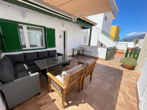 a patio with a couch and a table and chairs at Newly renovated apartment with 2 terrace, 2 bedroom, 5min beach in Puerto de Santiago