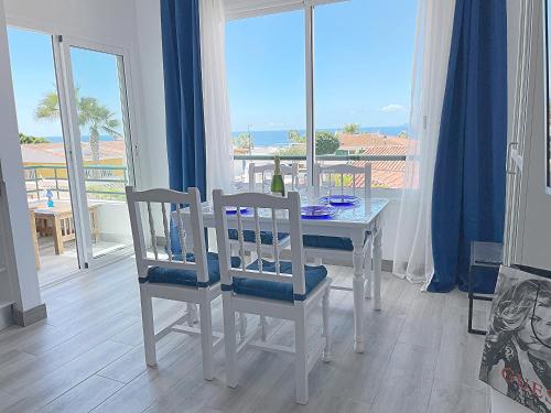 a dining room with a table and chairs and a window at Newly renovated apartment with 2 terrace, 2 bedroom, 5min beach in Puerto de Santiago